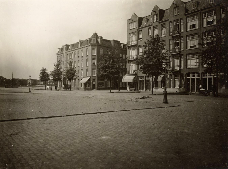  Krugerplein 22-28 (v.r.n.l.) met ingang Reitzstraat; het volgende blok links is Krugerstraat 2 t/m 30 (vrnl.). Datering zo rond juli 1924.<br />Bron: Beeldbank Stadsarchief Amsterdam 