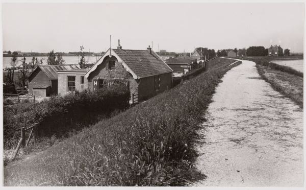 Diemerzeedijk. De Diemerzeedijk met op de achtergrond links: het Nieuwediep en rechts: het Gemeenlandshuis.<br />De foto dateert van ongeveer juni 1938. Bron: Beeldbank Stadsarchief Amsterdam 