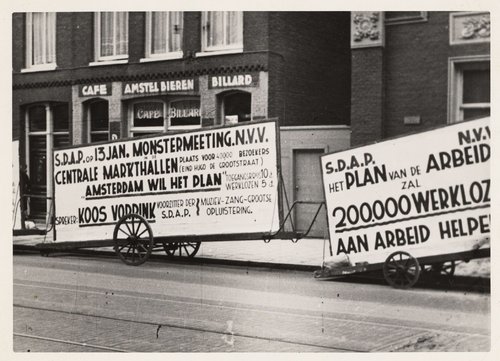 Propaganda van de SDAP. Karren met propagandaborden voor een monstermeeting (bijeenkomst) van de SDAP. Deze foto dateert van 1936 en is gemaakt door de heer Van Angelbeek.<br />Bron: beeldbank, Stadsarchief Amsterdam. 