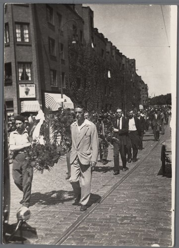 Jordaanoproer. De begrafenisstoet voor het eerste dodelijke slachtoffer van het Jordaanoproer, Johannes Adolphus Gerressen, 27 jaar en lid van de OSP, die op donderdag 5 juli werd doodgeschoten op de Lindengracht in de Jordaan. <br />Deze foto is van 9 juli 1934 en gemaakt door: C.A.J. van Angelbeek (fotograaf)<br />Bron: Beeldbank, Stadsarchief Amsterdam. 