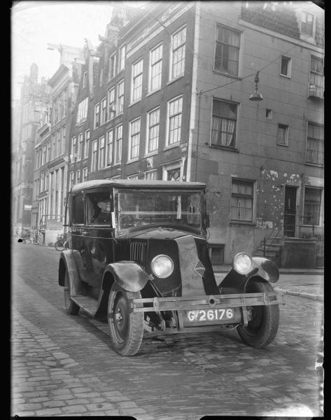 Taxi. Een taxi van het merk Renault in de Amsterdamse binnenstad in ongeveer 1934. Uit het fotoarchief van Paul Guermonprez, Bron: Beeldbank Gemeentearchief Amsterdam. 