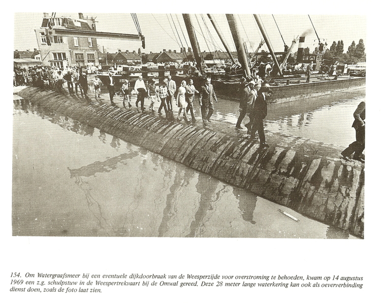  schulpstuw Om de Watergraafsmeer bij een eventuele dijkdoorbraak van de Weesperzijde voor overstroming te behoeden kwam op 14 augustus 1969 een z.g. schulpstuw in de Weespertrekvaart bij de Omval gereed. Deze 28 mter lange waterkering kan ook als oeververbinding dienst doen, zoals de foto laat zien.<br />Foto: Uit het boek WGM de geschiedenis van een polder van Jaap Kruizinga 