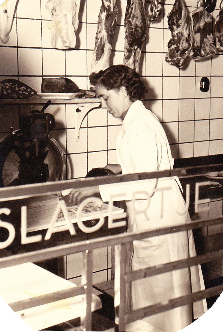 Het slagerinnetje 1956 De winkel heette `Het slagertje` zoals te lezen  is op de foto.<br />Mevrouw den Hartog  die op de foto staat, noemde zichzelf soms gekscherend ´het slagerinnetje´. 
