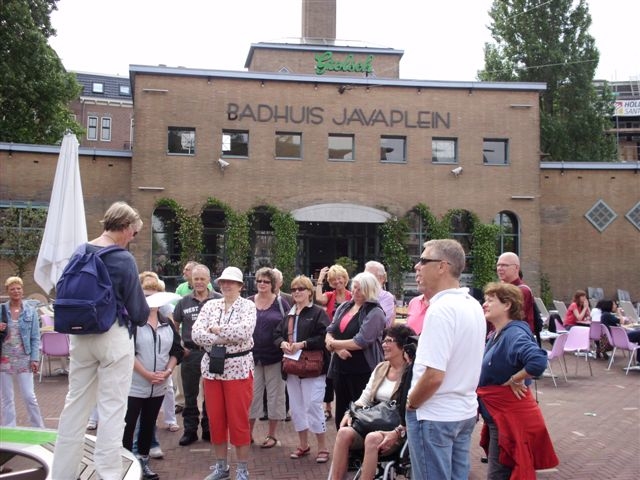 <br />Foto: John Haen Voor het Badhuis, tegenwoordig een horecagelegenheid, op het Javaplein werden enige herinneringen van oud-badhuisbezoekers voorgelezen. Ria staat hier in het midden met grote rode schoudertas.<br />Foto: John Haen 
