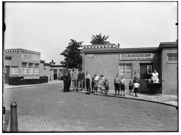 Het Zeeburgerdorp. Afgebeeld is de ingang van het Zeeburgerdorp. De foto is gemaakt op 8 juni 1934.<br />Bron: Beeldbank Stadsarchief Amsterdam. 