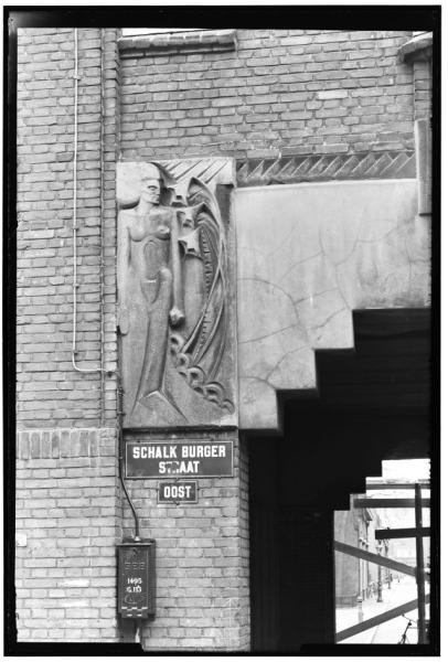 Versierde poort naar de Kraaipanstraat. Naast het poortje zaten vroeger ‘ornamenten’. Deze zijn in 1955 verwijderd, wat er met deze toch wel bijzondere objecten is gebeurd is helaas onbekend.<br />Bron: Beeldbank, Stadsarchief Amsterdam. 