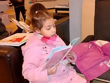 dochtertje van Sabria Verdiept in een boek in de bibliotheek, voorjaar 2014. Foto: Sabria 