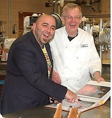 ace of cakes Duff Goldman - een t.v. beroemdheid- bekijkt met Robert Min foto's in de bakkerij in Amerika 