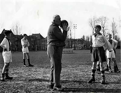  Trainer Reynolds met een paar jeugdige Ajaxieden tijdens een training op het veld voor het stadion aan de Middenweg. (Jaren 50 van de vorige eeuw). 