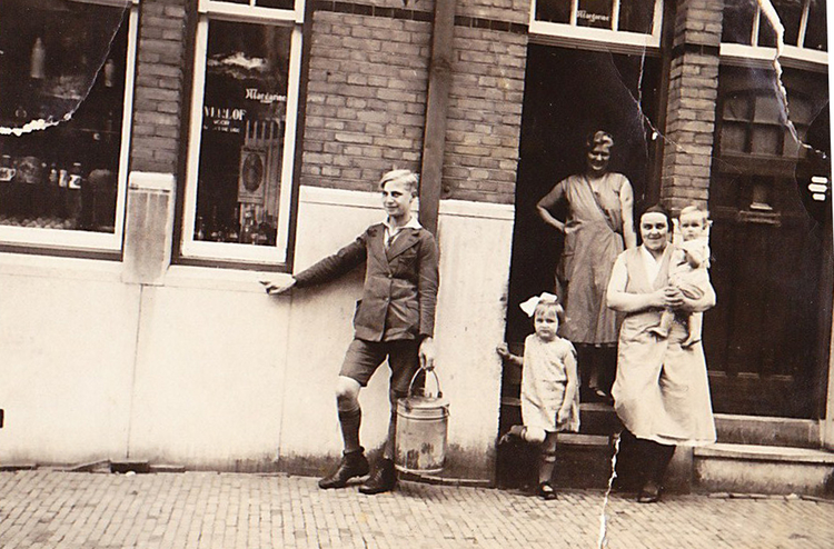 Paardekraalstraat 08. Voor de winkel staan van links naar rechts: het hulpje Jan (we noemden hem Jan Lunapark, maar zo heette hij niet echt), Fie, het winkelmeisje Alie Smit en moeder met Aaltje op de arm.<br />Foto uit 1932. 
