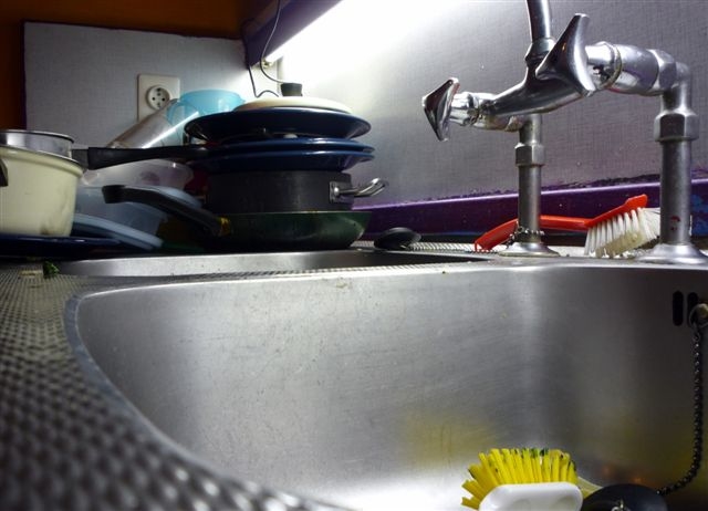 Afwas in een keukentje in Casa 400, 2009. Meestal staat er een hoop afwas op het aanrecht en liggen er lege flessen. 