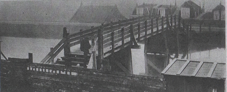 Brug over de Ringvaart (1927). Watergraafsmeer is/was wel een van de Amsterdamse buurten, die voor voetgangers en voertuigen het moeilijkst te bereiken was (in de jaren twintig!). Spoorwegovergangen en ongelukkige wegen als de Ringdijk vormden beletselen. Na lang aandringen van de bewoners van het belangrijke wooncomplex achter de Ringdijk is er dan eindlijk een noodbruggetje over de Ringvaart gekomen, echter niet tegenover de druk bevolkte wijk, maar in het verlengde van de Schalk Burgerstraat. Aaan de andere kant komt het bruggetje uit bij een beorderij. Daardoor ligt het bruggetje ongeveer 10 minuten van de druk bezochte buurt van Willem Beukelsstraat etc. Met andere woorden, de bewoners hebben er nog niet veel aan.<br />BronL Stadsarchief Amsterdam, Collectie Haijen (inv.nr. 15002-319). 