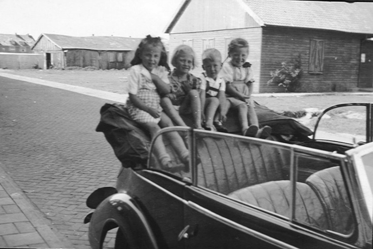  Op de linnen kap op de auto van buurman Schagen voor het huis in de Finsenstraat (1950), vlnr: Toos van der Wusten, Anita en Michiel Schagen en Magdaleen. 