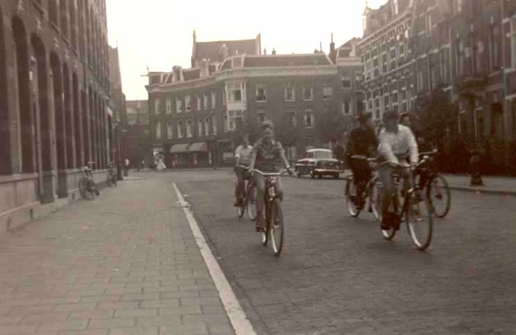 1959, fietsen in de Tweede Oosterparkstraat halverwege het laatste blok in de richting van het Kastanjeplein. Linksvoor fietst Bernard, daarnaast zijn buurjongen en vriend Han Moes en achter hen Loek Moes. 