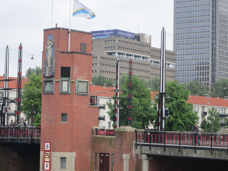 Hier is de 4 meter hoge keramische plaat op de toren goed te zien, met de Genius van Amsterdam zoals zij uit het water oprijst.  
