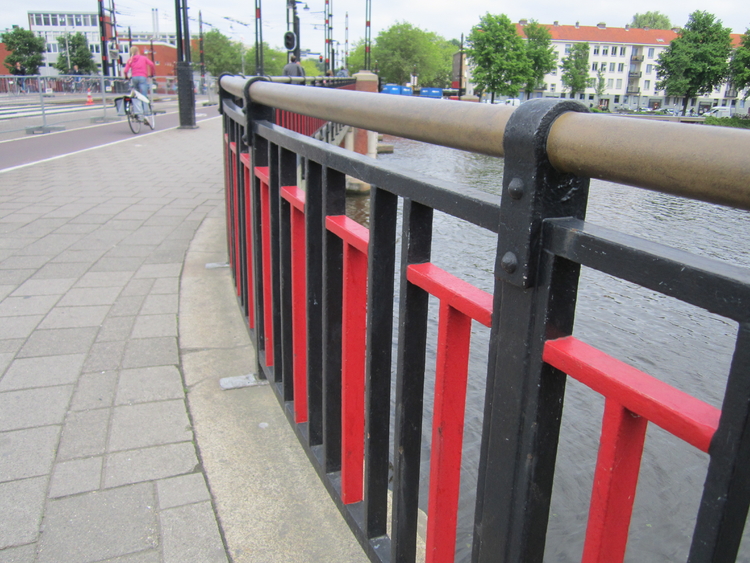 De rood/zwarte kleuren van de leuning, de kleuren van Amsterdam.  