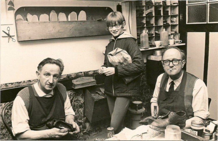 Ger en broer Co in de werkplaats. De zus van Rendi, Hennie, staat er achter met een papieren schoenenzak - ± 1955 .<br />Foto: Ria Smith-Haije 