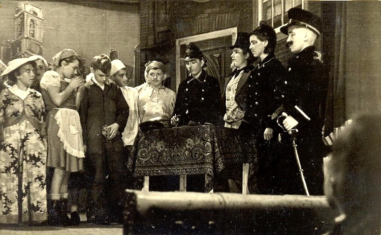  De toneelspelers op het afscheidsoptreden ‘Jan Lustig’, 1950. Het ‘giftig’ veldwachtertje naast zijn bureau rechts op de foto is Piet Muller. 
