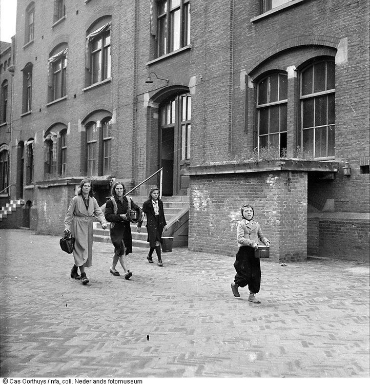  Inwoners lopen in de hongerwinter met pannen naar een gaarkeuken, Amsterdam (1944-1945).  Maker van de foto is Cas Oorthuys, bron: www.geheugenvannederland.nl 