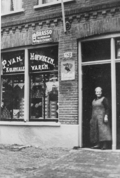  Oma Van Hofwegen in de deuropening van het winkeltje met koloniale waren op nummer 98 in de Von Zesenstraat. 