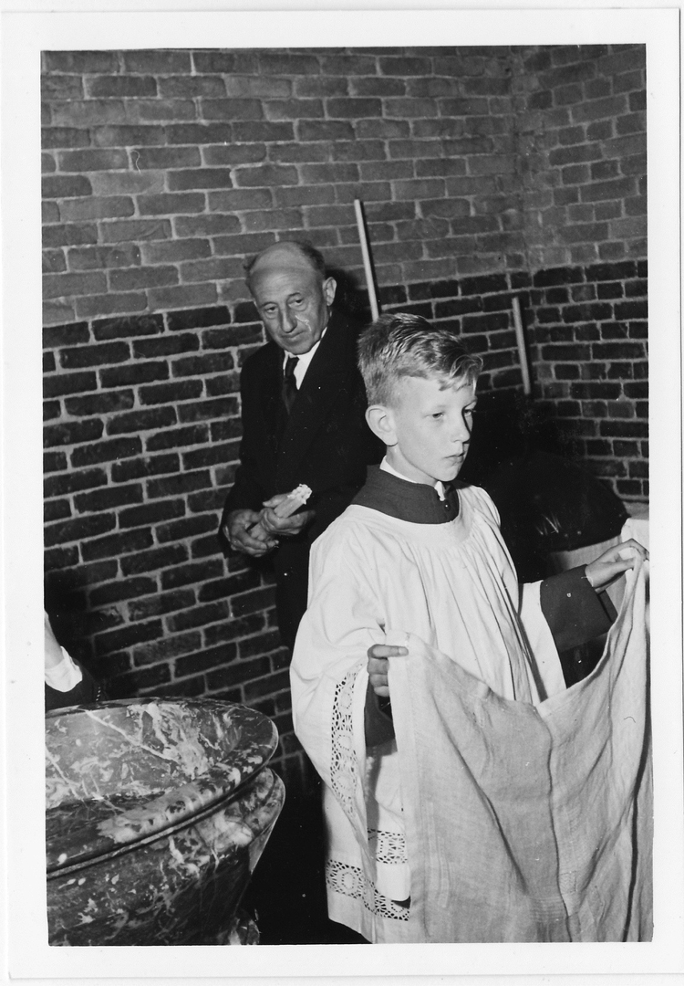 Misdienaar Paul als misdienaar Tijdens de doop van mijn zusje Leonie houd ik de doek op om haar hoofdje af te drogen. Achter mij: de koster 