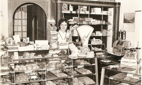  Dochter Ineke achter de toonbank (1958). Zij heeft jarenlang in de winkel gestaan.<br />(foto: Ineke Blok-Haen) 