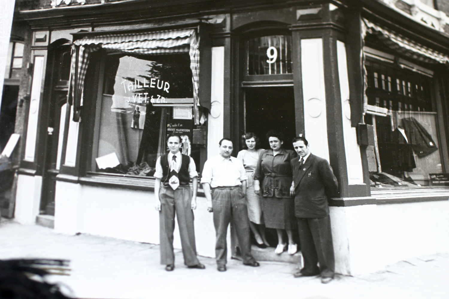 De winkel Tailleur Vet op de hoek P. Vlamingstraat en Dappermarkt, staan van links naar rechts Joop Vet, Ben Vet en vrouw, en moeder en vader Vet omtreeks 1953-1955. - Geheugen
