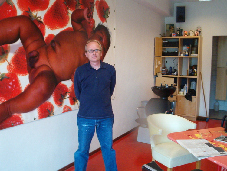  mpoort Kees Hartog voor de grote fotocollage op zeil in zijn kapperszaak (2005). De collage heet 'aardbeienbaby's' en is van zijn Spaanse vrouw Prado. 