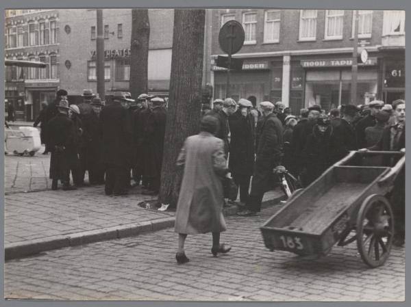 Eerste Van Swindenstraat, ongeveer 1941. Mensen op straat in de Eerste Van Swindenstraat, gezien naar het Van Swindentheater.<br />De foto is gemaakt door Bart de Kok (fotograaf). Bron: Beeldbank, Stadsarchief Amsterdam. 