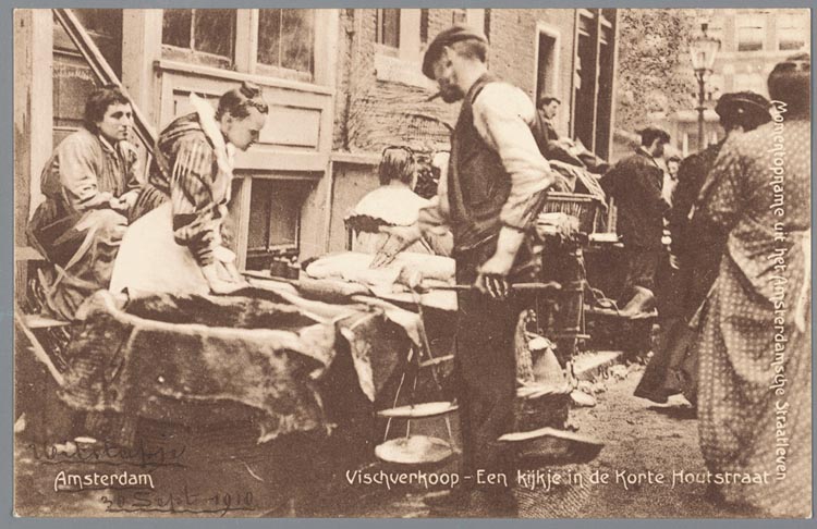 'Vischverkoop' in de Korte Houtstraat. Prentbriefkaart van een viskraam in de Korte Houtstraat in de Amsterdamse Jodenbuurt met visweger Kool, 1910. Vader Smeer woonde in dit drukke straatje!<br />JHM, Collectie Jaap van Velzen. 