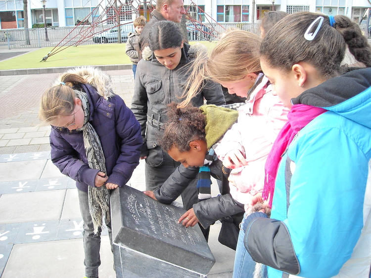 Joubertplein Kinderen van de Lidwinaschool proberen de tekst op de steen te lezen. Het monument staat in de speeltuin op het Joubertplein ter nagedachtenis aan de omgekomen kinderen. 