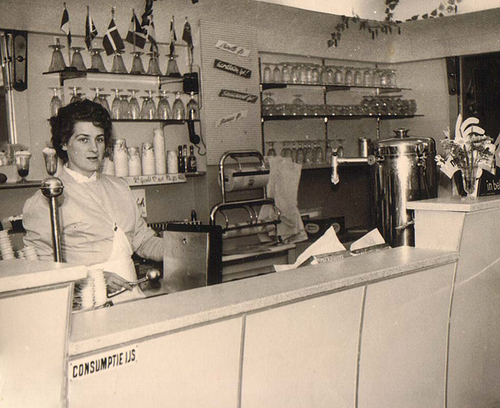 1960: IJswinkel is pas gekocht Mevrouw Massaro achter de toonbank van 'Massaro's ijssalon'.<br />copyright Giovanni Massaro. Moeder Aaf Massaro staat achter de toonbank als trotse eigenaar. 