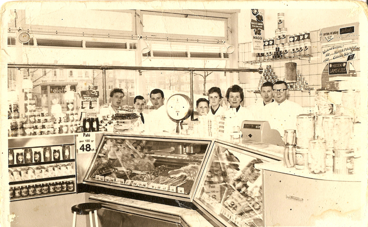  De winkel van Slager Mulder rond 1957. Herman en Jaap staan hier rechts van de weegschaal samen met hun ouders en personeel.<br />Foto: Herman Mulder 