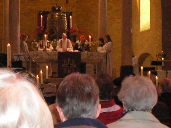 Kardinaal Simonis (rechts met rood hoofddeksel)  samen met pastor Nico Essen en misdienaars op het altaar.  
