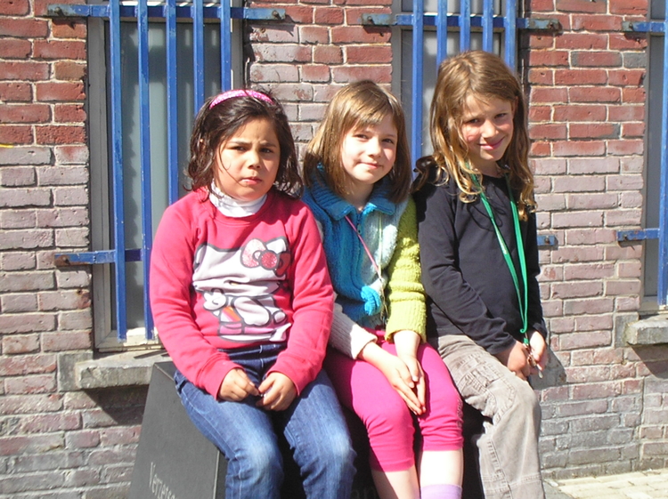  Er is een monument gekomen voor Eli van Tijn. Het staat voor de school. Hier zie je 3 meisjes uit de buurt, die erop zitten. 