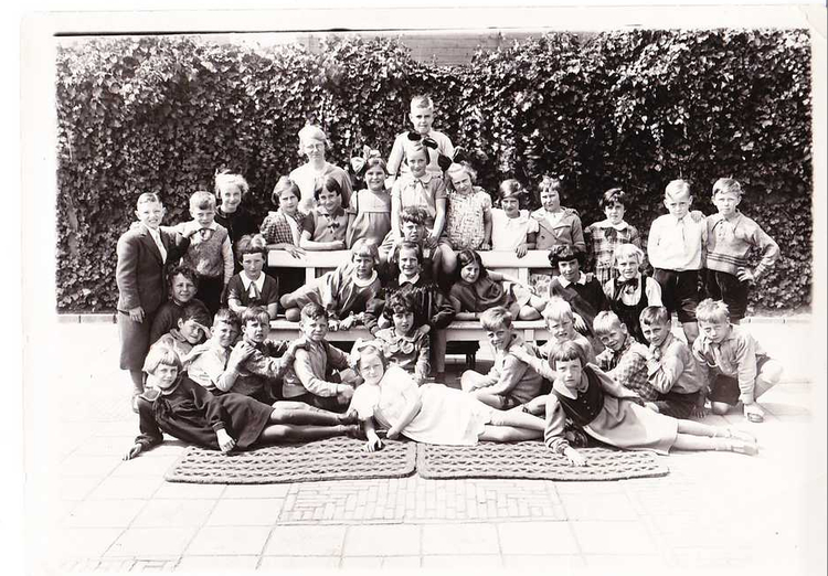 Foto uit 1935 van de 3e klas van de Pieter Nieuwlandschool (Betondorpschool) Foto uit 1935 van de 3r klas van de Pieter Nieuwlandschool. De footo is genomen in de achtertuin aan de Zuivelweg. Alie is het meisje met strik dat rechts naast de hoogst geplaatste jongen staat, juffrouw Tenon staat links van de jongen. 