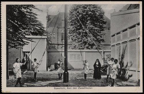 St. Elisabeth Gesticht (1920) Bij het Gesticht was een speeltuin voor de weeskinderen van Het Maagdenhuis. Er was o.a. een zweefmolen (Uitgave Brinio, Rotterdam). Alles onder toeziend oog van een Eerwaarde Zuster.<br />Deze prentbriefkaart is afkomstig van: Beeldbank, Stadsarchief Amsterdam. 
