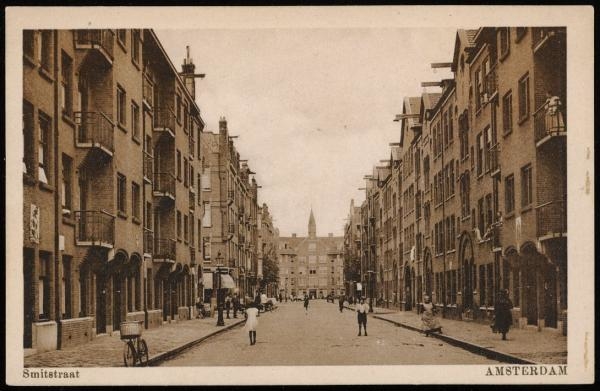 Smitstraat richting Retiefstraat. Al lopende door de Smitstraat kom je aan het eind in de Retiefstraat 43-45 (het torentje is nog net zichtbaar). Uitgave G.J. Jong. Deze afbeelding van een prentbriefkaart dateert uit 1934. Bron: Beeldbank, Stadsarchief Amsterdam. 