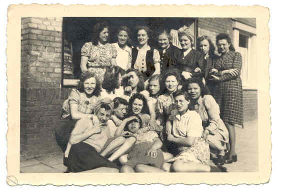  Moeder Coby, zittend op de grond (midden) met de meisjes van het naaiatelier waar ze voor haar huwelijk werkte (1950) 