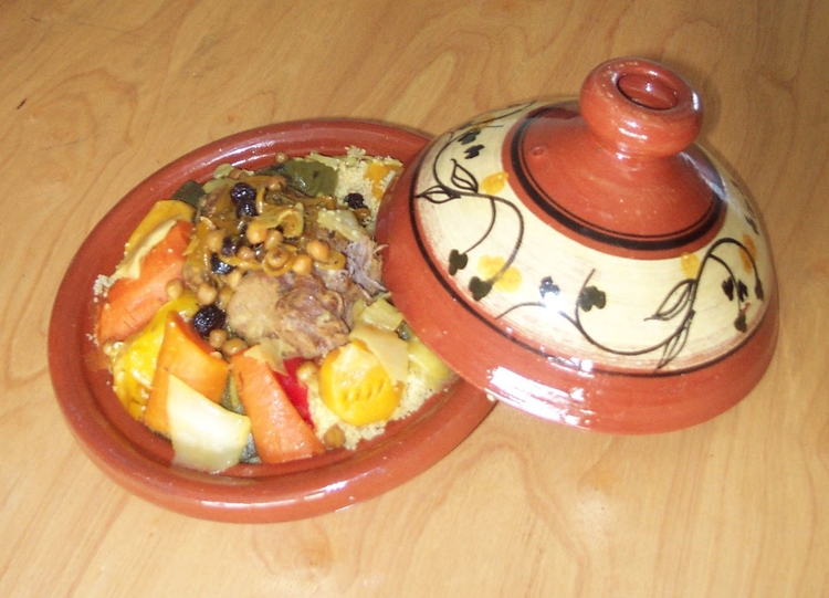  Een Tajine is een Marokaanse manier van bereiden eten in een aardewerken schotel. Er kan van alles inklaargemaakt worden. In dit gerecht zat lamsvlees met couscous, wortelen, kool, nootjes en krenten. 