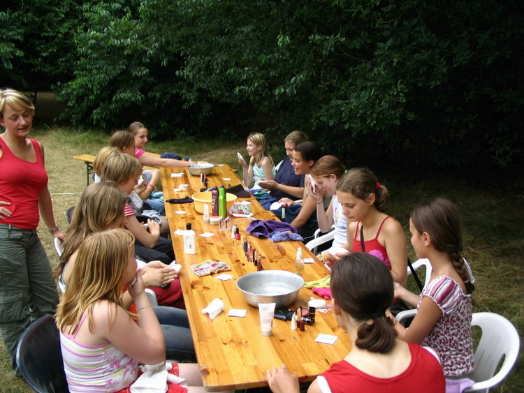 Eten aan een lange tafel. De gidsen eten met z'n allen aan een lange tafel. Er wordt bij Scouting Oost geen uniform gedragen. 
