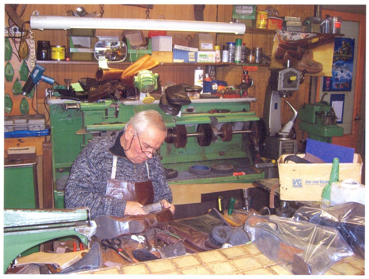 schoenmaker Op de achtergrond is een machine zichtbaar die nog met Marshall hulp is verworven. Foto gemaakt in november 2008.. 