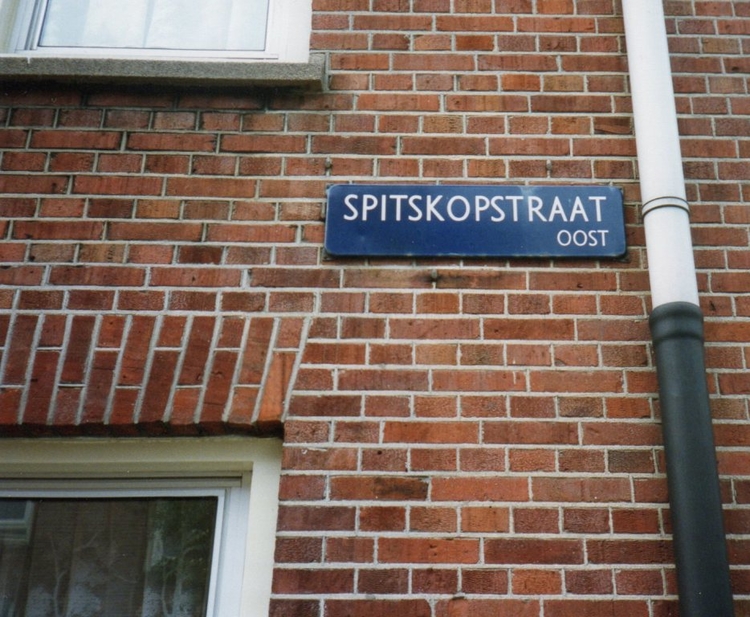 Straatnaambordje Spitskopstraat. Aan het begin van de jaren zestig heeft Maurice Ferares deze foto gemaakt. Hij is geboren in de Spitskopstraat, nummer 1 huis. 