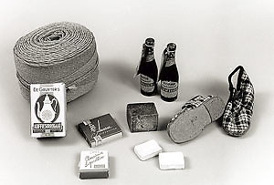  Voorbeelden van surrogaatproducten. <br />Een rol touw gemaakt van papier, een flesje en een pak koffiesurrogaat, kinderpantoffels met kartonnen zolen, surrogaatzeep, sigaretten van Nederlandse tabak!<br />Bron: Verzetsmuseum (www.verzetsmuseum.org ) 