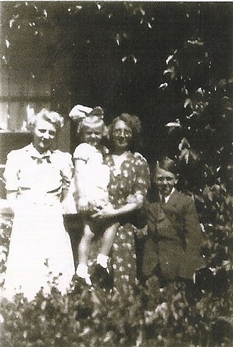 Tuin Zomer 1940 in de tuin in de Veeteeltstraat: Wil op de arm van  haar moeder met haar broer en zus. 