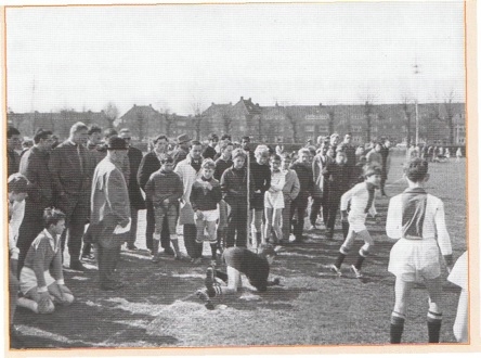  Op het voorterrein van het Ajax-stadion werd op zaterdagochtenden gevoetbald door tientallen jongens die hoopten door hun spel in de zo roemrijke Amsterdamse club te komen. Zoals op deze foto van 16 april 1967, onder het oplettend oog van 3ohan Cruijff en Ton Pronk. [SPAARNESTAD PHOTO] 