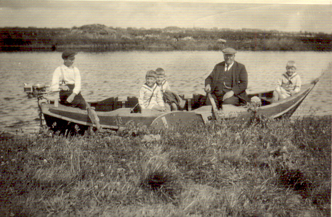  Opa Jacob de Rooy (vervener) met kleinzonen in een bootje in de Volgermeerpolder om de baggerwerkzaamheden aldaar te bezoeken. Aan het roer de zoon van sluiswachter Catsburg. <br />(Foto: Henk de Koning) 