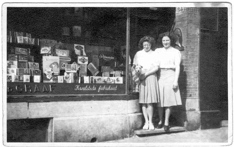  Mevrouw Angeline van de Graaf (links) voor de sigarenwinkel van haar ouders, Middenweg 34 in 1943. 