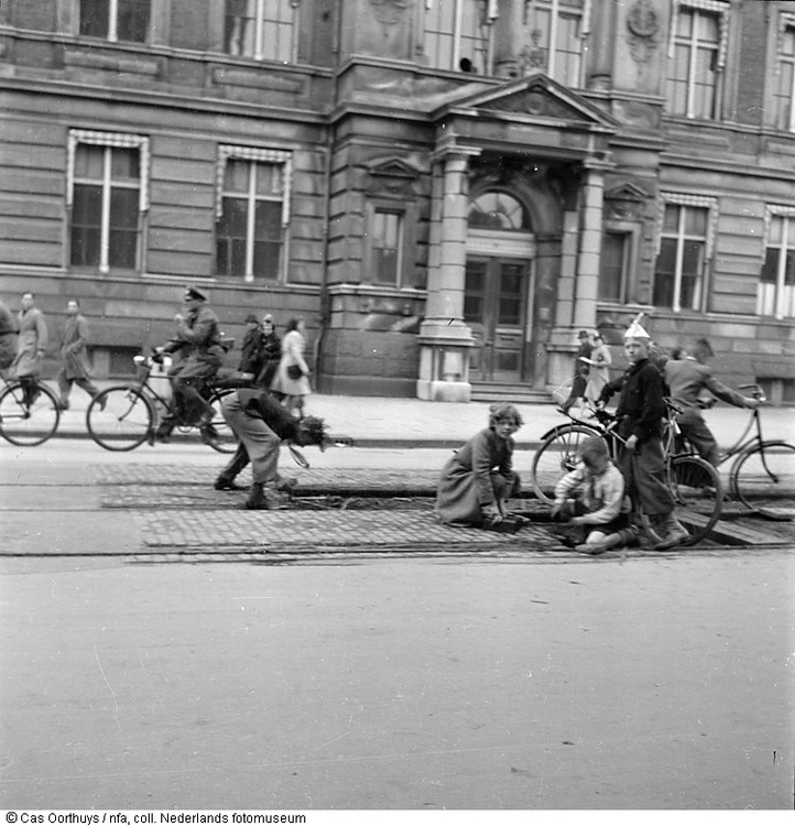 Tekort aan brandstof.  Inwoners verzamelen in de Hongerwinter tramspoorbielzen nabij het Barlaeus Gymnasium om als brandhout te gebruiken, Amsterdam (1944-1945). 