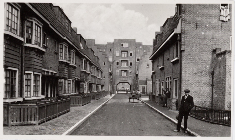 Kraaipanstraat. Kraaipanstraat 2-38 (links, v.r.n.l.), ontworpen door de architecten Gratama en Versteeg (1922-1923), gezien in oostelijke richting naar de achterzijde van de huizen aan de Schalk Burgerstraat. Rechts Kraaipanstraat 47-51 (v.l.n.r.).<br />Bron: Beeldbank, SAA. 